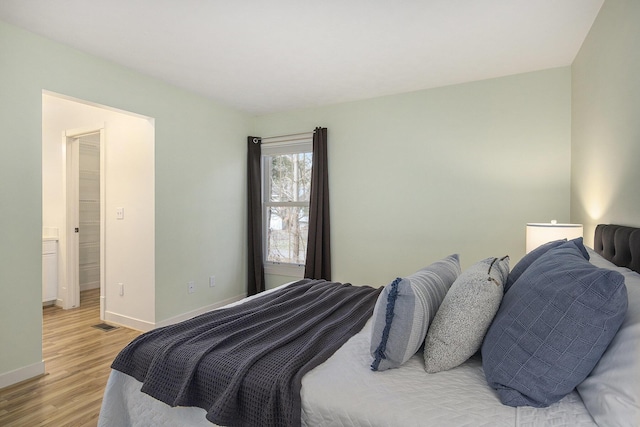 bedroom featuring baseboards and light wood finished floors