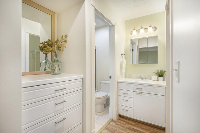 full bathroom with toilet, wood finished floors, and vanity