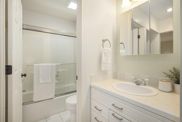 full bath with tile patterned flooring, toilet, vanity, and shower / bath combination with glass door