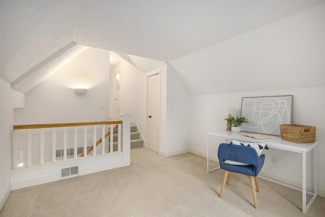 carpeted office space featuring visible vents, baseboards, and vaulted ceiling