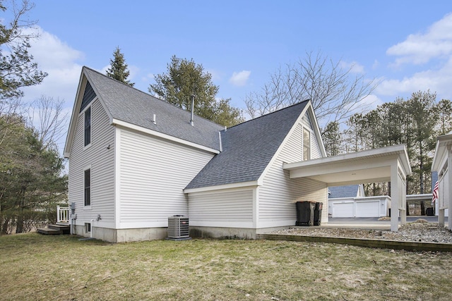 back of property featuring a carport, central AC, a yard, and roof with shingles