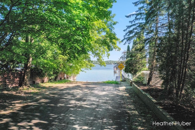 property view of water with a dock and fence