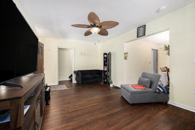 sitting room featuring dark wood-type flooring, a ceiling fan, and baseboards