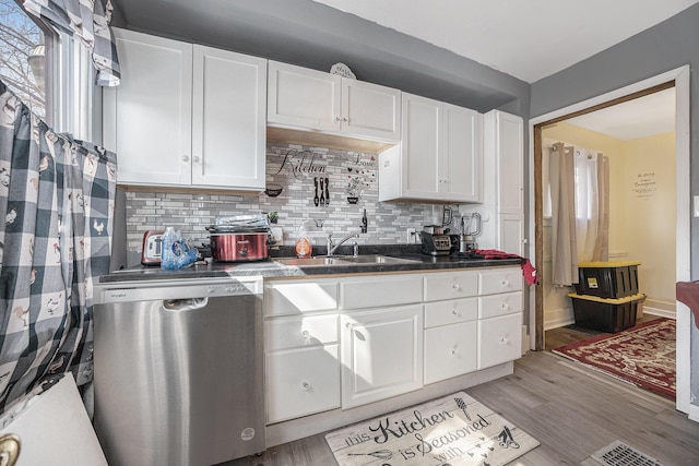 kitchen featuring light wood finished floors, a sink, white cabinets, and stainless steel dishwasher