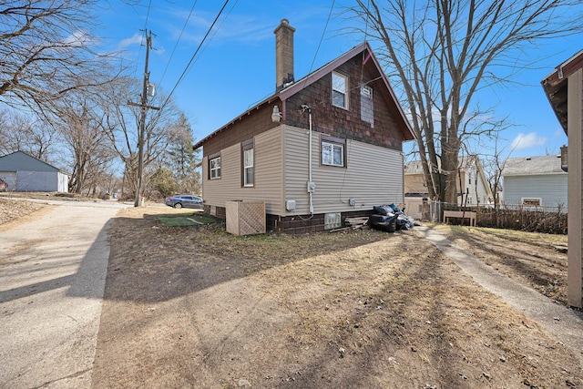 view of side of home with a chimney and fence