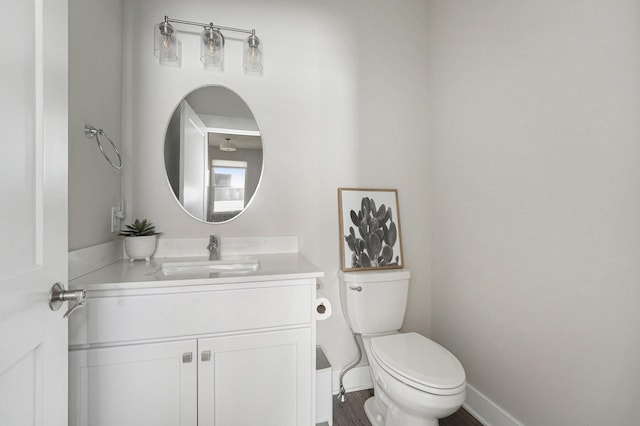 bathroom with vanity, toilet, and baseboards