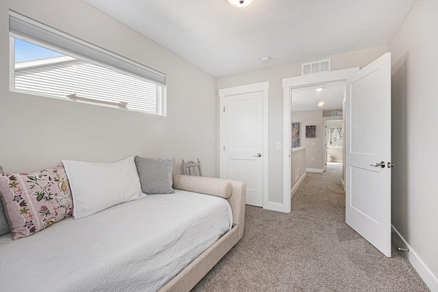 bedroom featuring visible vents, light colored carpet, and baseboards