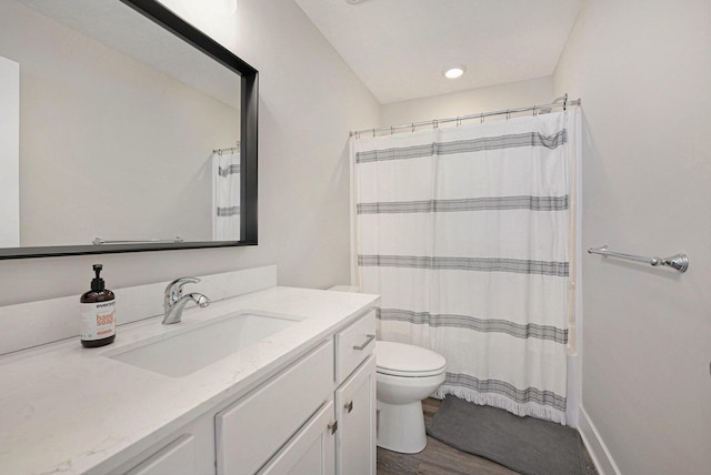 bathroom with vanity, a shower with curtain, toilet, and wood finished floors