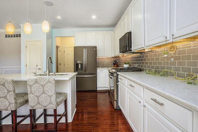 kitchen with visible vents, dark wood finished floors, a sink, stainless steel appliances, and light countertops