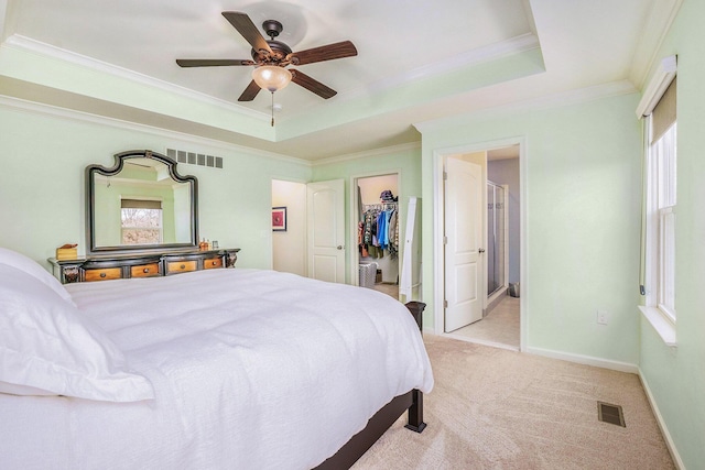 bedroom featuring a tray ceiling, light carpet, and visible vents