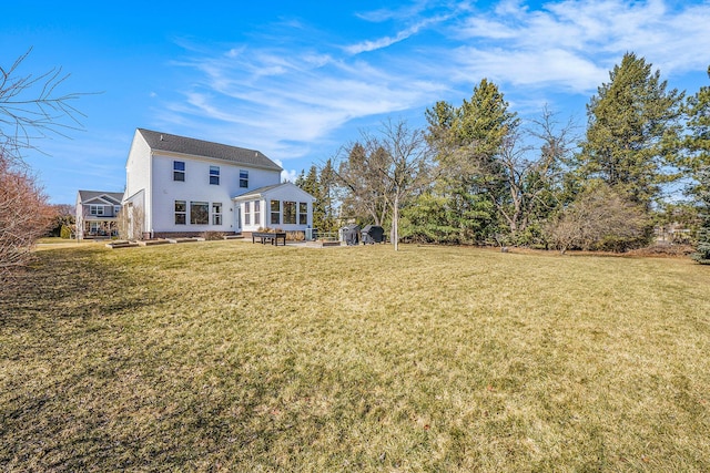 back of house featuring a lawn and a sunroom