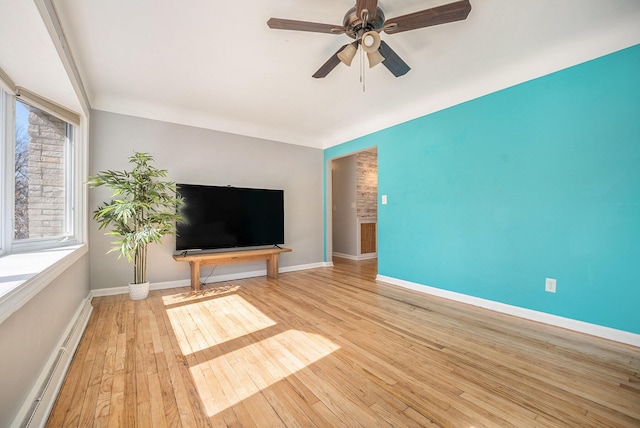 unfurnished living room featuring ceiling fan, a baseboard radiator, baseboards, and hardwood / wood-style flooring