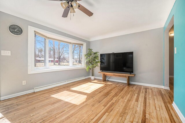 unfurnished living room with a baseboard radiator, baseboards, wood finished floors, and a ceiling fan