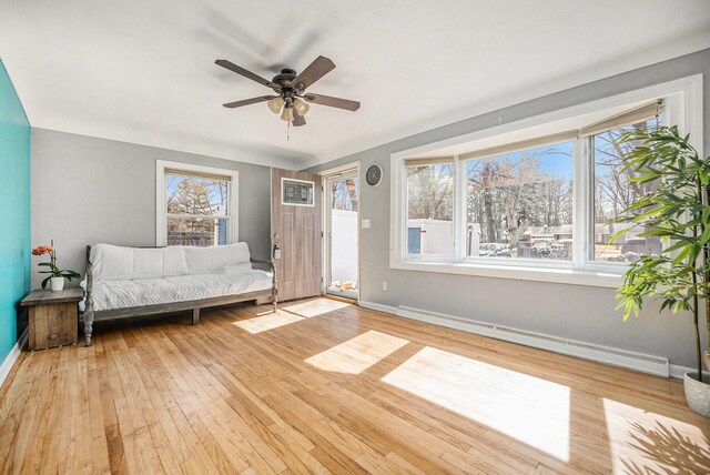 unfurnished room featuring light wood-style flooring, a baseboard heating unit, baseboards, and ceiling fan