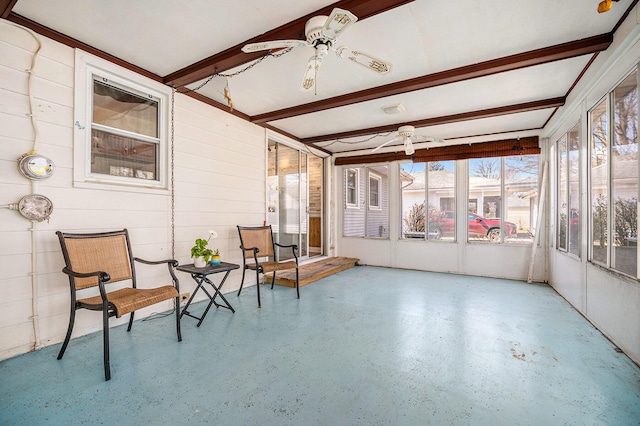 sunroom featuring beamed ceiling and a ceiling fan