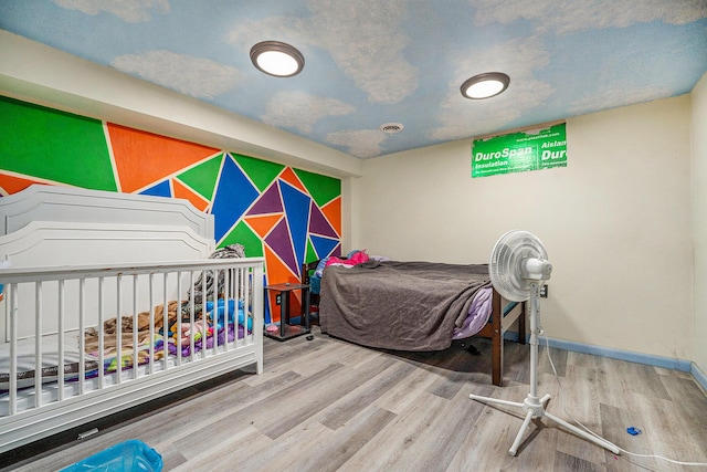 bedroom with baseboards and wood finished floors