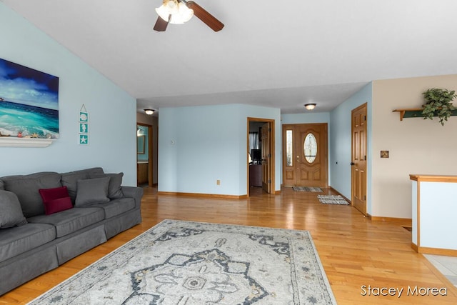 living room featuring light wood-style floors, baseboards, and ceiling fan