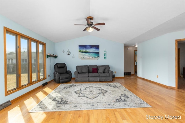 living area with vaulted ceiling, ceiling fan, baseboards, and wood finished floors