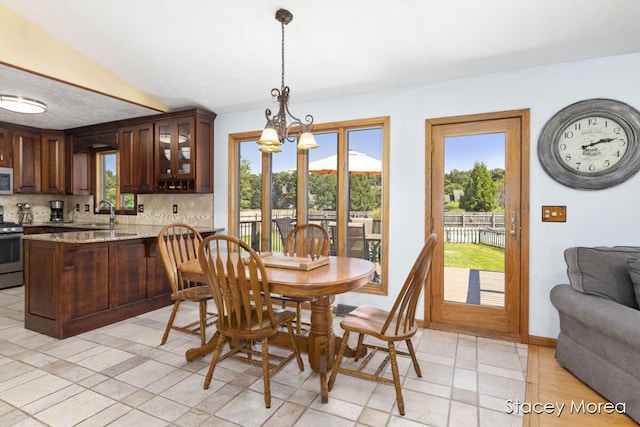 dining room with a notable chandelier, a healthy amount of sunlight, and baseboards