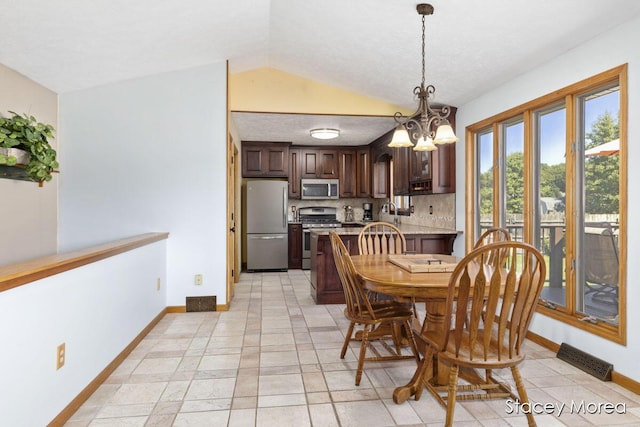 dining room with an inviting chandelier, lofted ceiling, baseboards, and visible vents