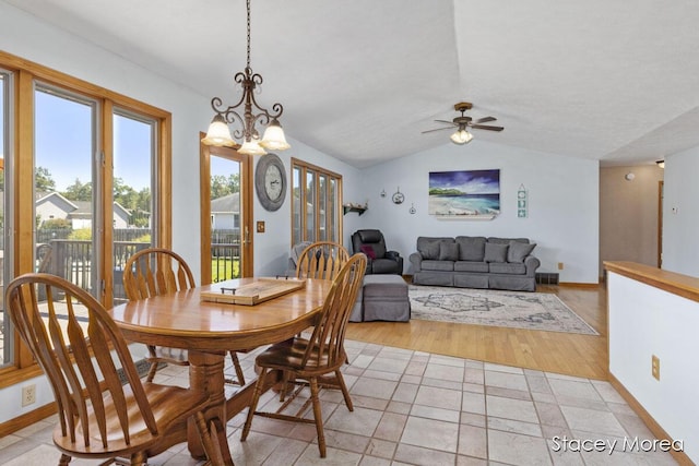 dining room featuring baseboards, lofted ceiling, and ceiling fan with notable chandelier