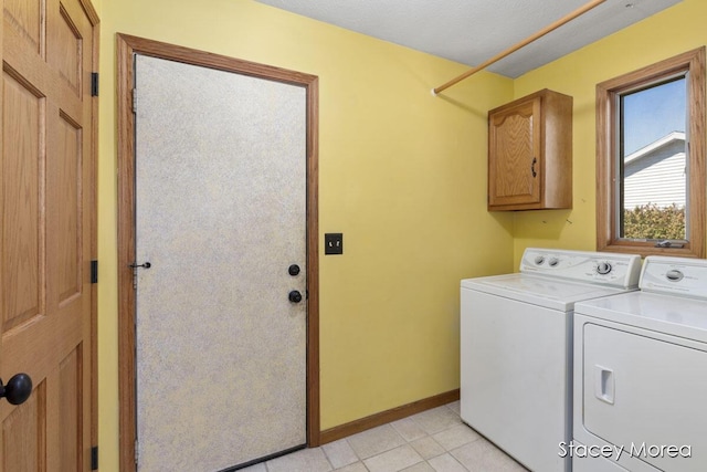 washroom featuring light tile patterned flooring, cabinet space, independent washer and dryer, and baseboards