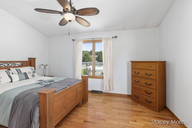 bedroom featuring light wood-style flooring, a ceiling fan, and baseboards