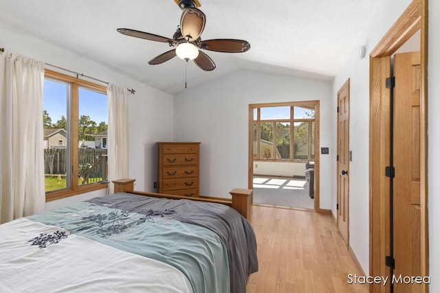 bedroom featuring multiple windows, lofted ceiling, baseboards, and light wood-style flooring