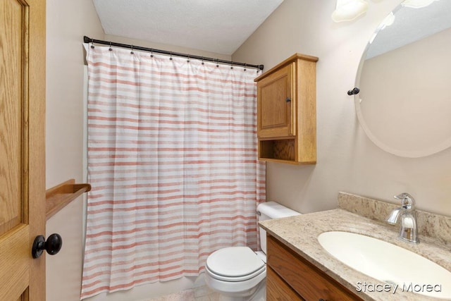 full bath with vanity, toilet, and a textured ceiling