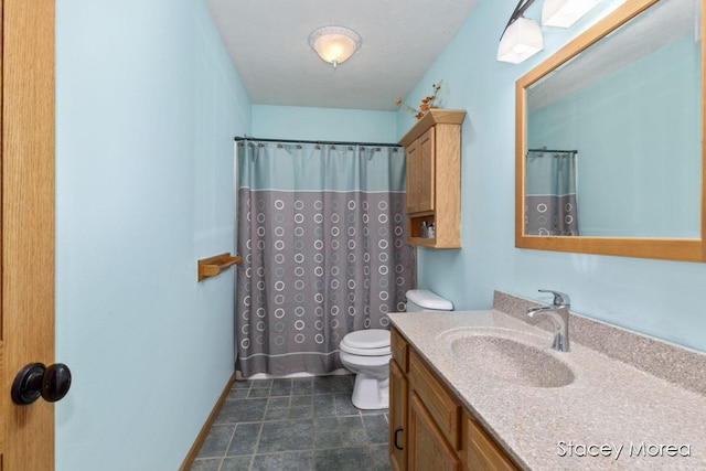 bathroom with vanity, toilet, a shower with curtain, and baseboards