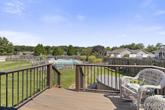 wooden deck featuring a yard, a fenced in pool, and a fenced backyard