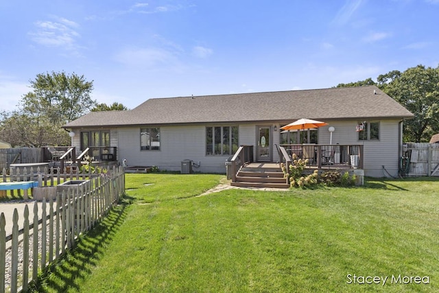 back of property with a yard, central AC, a wooden deck, and a fenced backyard