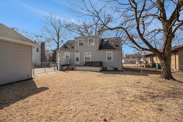 back of property featuring central air condition unit, a gate, and fence