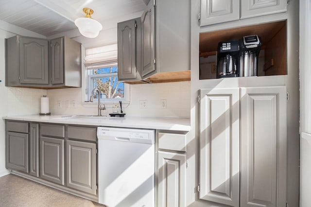 kitchen featuring tasteful backsplash, a sink, gray cabinetry, and white dishwasher