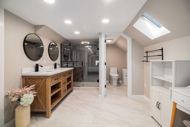 bathroom with a shower stall, lofted ceiling with skylight, toilet, marble finish floor, and vanity