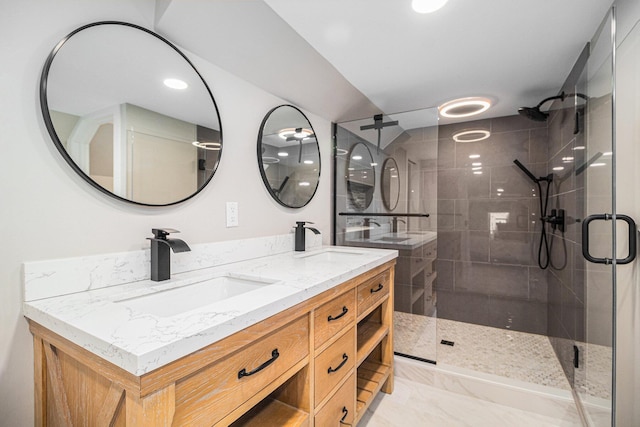 bathroom featuring a shower stall, double vanity, and a sink