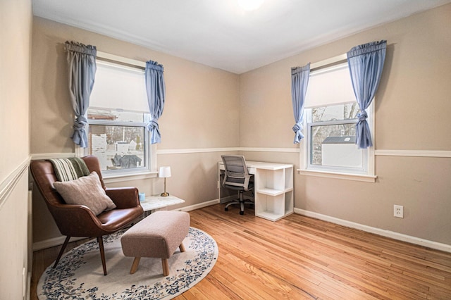 living area with baseboards and wood finished floors