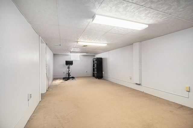 exercise room featuring a paneled ceiling and light colored carpet