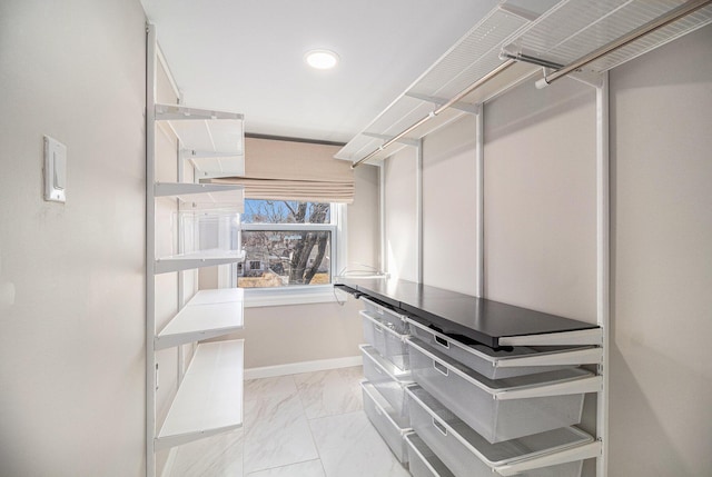 spacious closet featuring marble finish floor