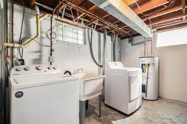 laundry area featuring water heater, laundry area, a healthy amount of sunlight, and washing machine and clothes dryer