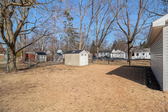 view of yard with an outdoor structure, a storage shed, and a fenced backyard