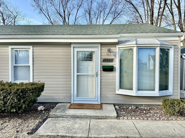 entrance to property with roof with shingles