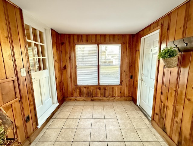 entryway featuring wooden walls and light tile patterned floors