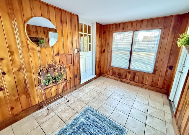 foyer with light tile patterned floors and wooden walls