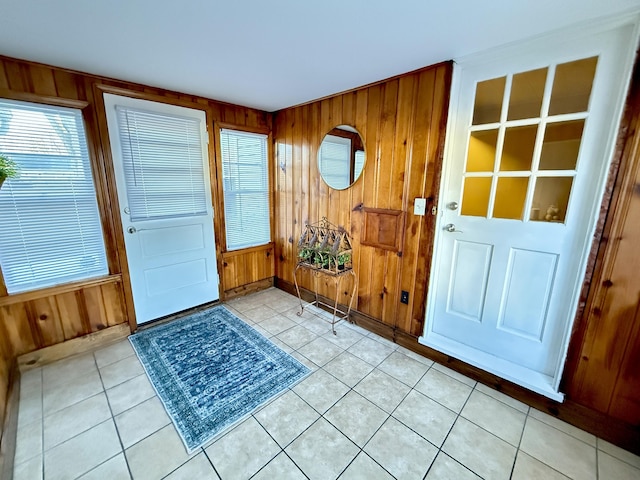 entrance foyer with light tile patterned floors and wooden walls