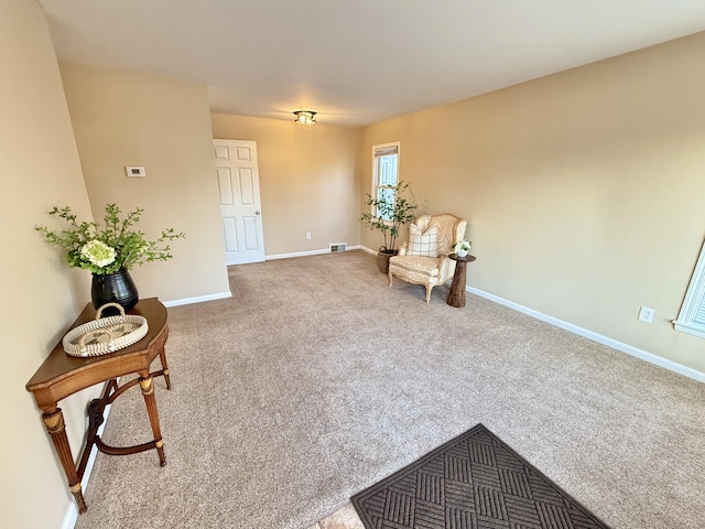 living area with visible vents, baseboards, and carpet floors