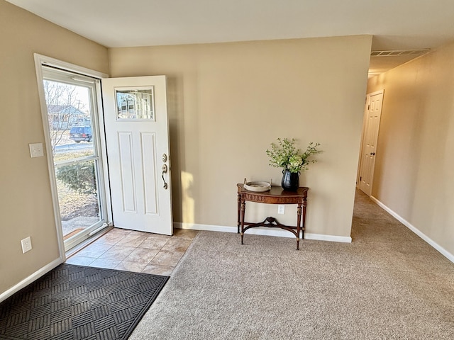 entrance foyer featuring visible vents, baseboards, and light carpet