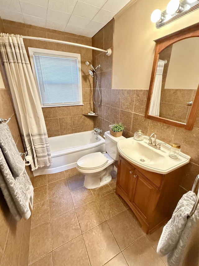 full bathroom featuring tile patterned floors, toilet, tile walls, shower / tub combo, and vanity