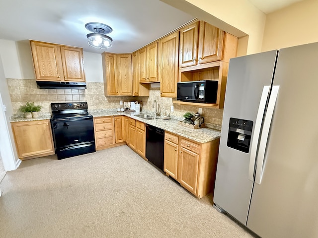 kitchen featuring under cabinet range hood, decorative backsplash, black appliances, and a sink