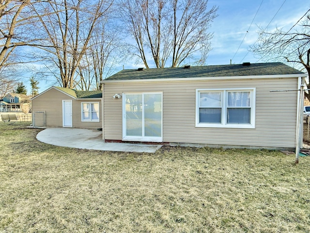 rear view of property featuring a patio and a lawn